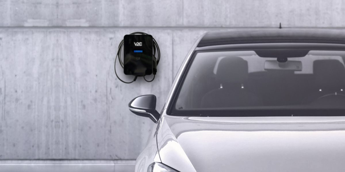 V2C Trydan ladestander monteret på væg ved siden af elbil